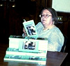 Photograph of Doris Johnson reading a copy of Jean of Storms