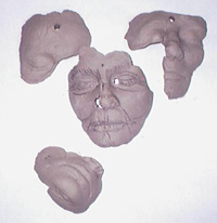 shows partial masks of faces in clay