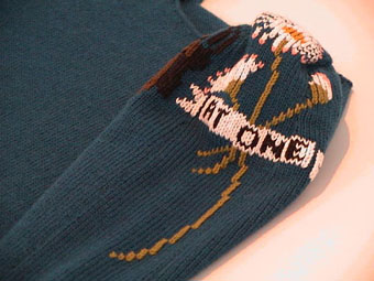 Close up of 'At One' embroidery on Catherine Long's sweater