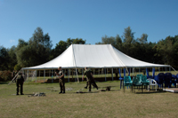 Colour photograph of a marquee being taken down by soldiers - first in a series of four