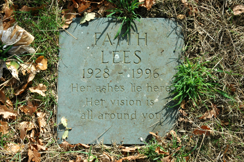 Close-up colour photograph of a memorial stone set in the grass, reading 'Faith Lees, 1928-1996, Her ashes lie here, Her vision is all around you