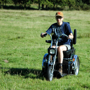 Colour photograph of me riding towards the camera over a field.