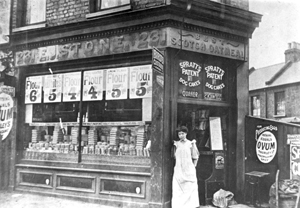 Black and white photograph of a woman outside a shop