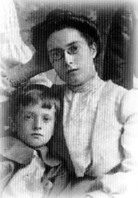 Black and white portrait of Elsie Oxenham, probably in her 30s, with a small boy