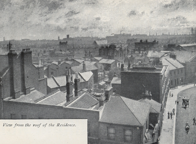 Black and white photograph of roofs and chimneys against the sky