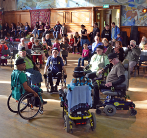 Wheelchair dancers move into a circle together in the centre of a dance hall