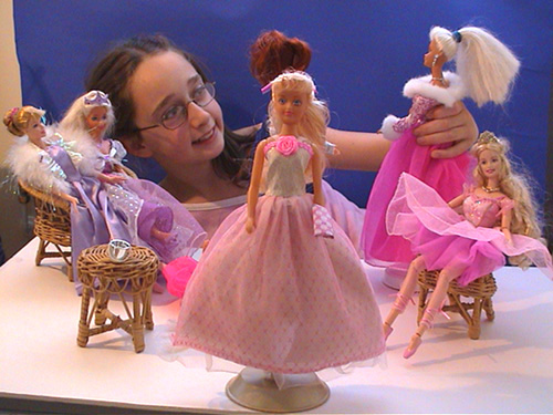 Photo von einem Madchen, welches Puppen fur die Photographien in Position setzt.