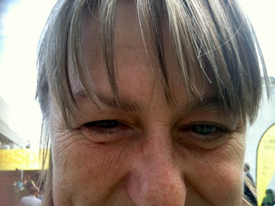 Close up colour photograph of a woman with blonde hair looking straight at the camera.