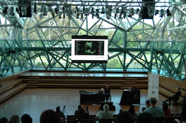 Colour photograph of Ju presenting her work at the symposium.