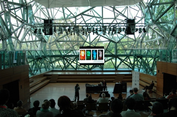 Colour photograph of Ju presenting her work at the symposium.