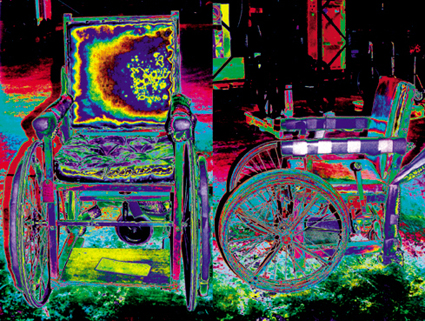 This is a colour photograph of old-fashioned wheelchairs in the Science Museum stores, digitally manipulated so that they glow with bright colours.