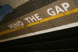 Colour photograph of a tube station platform with 'mind the gap' written on it