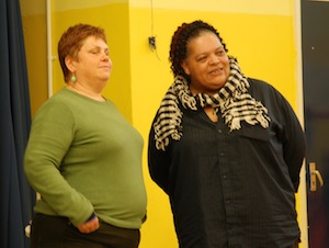 Colour photograph of two women standing together as they improvise a scene